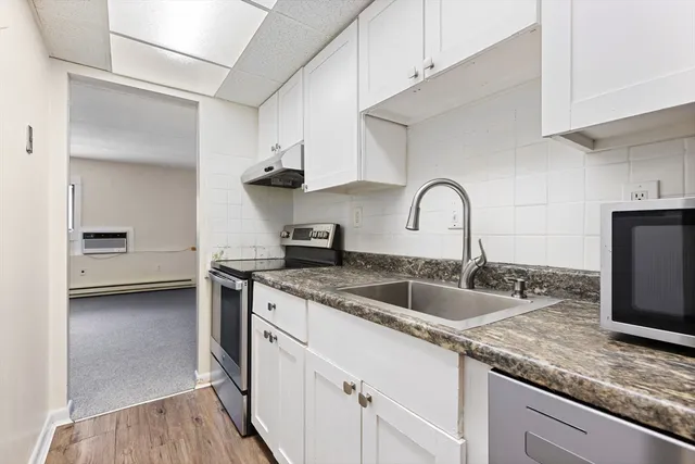 a kitchen with granite countertop a sink stainless steel appliances and cabinets