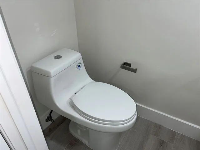 a white toilet sitting next to a white cabinet