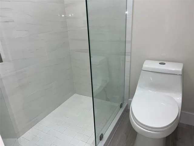 a bathroom with a toilet and a shower