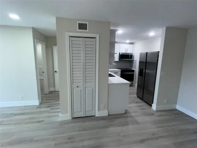 a view of a refrigerator in kitchen and wooden floor