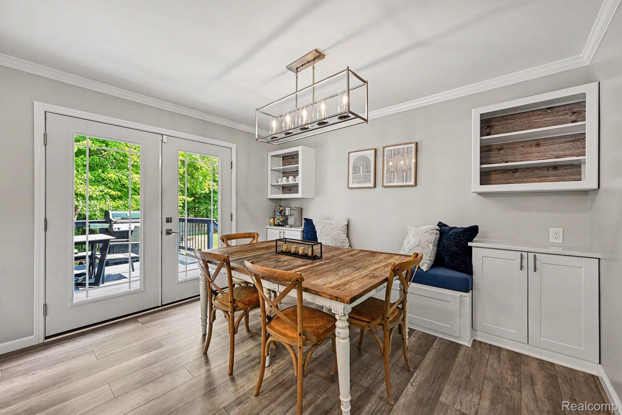2104 Highfield Road Waterford, MI 48329 - Photo 11 of 38 LVP flooring, built-in bench seating, white cabinetry with integrated shelving, and French doors opening to two outdoor decks