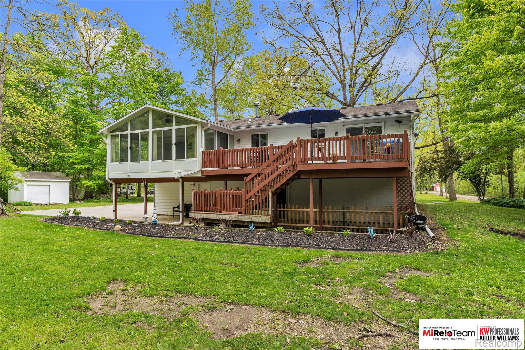 10191 Judd Road Willis, MI 48191 - Photo 26 of 39 Back of property with a sunroom, a yard, a deck, and an outdoor structure