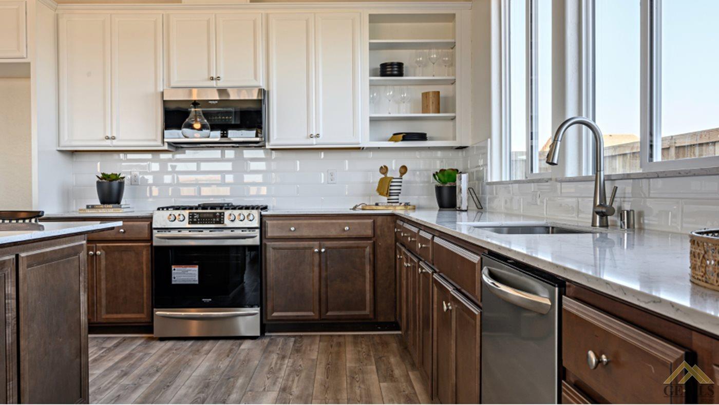 Undisclosed Address Bakersfield, CA 93313 - Photo 2 of 17 a kitchen with stainless steel appliances granite countertop a stove a sink and a microwave