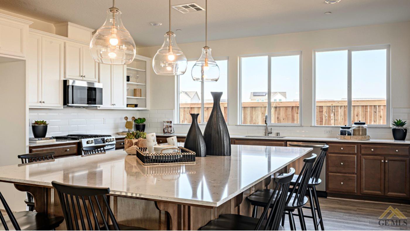 Undisclosed Address Bakersfield, CA 93313 - Photo 3 of 17 a kitchen with kitchen island granite countertop a table chairs sink and cabinets