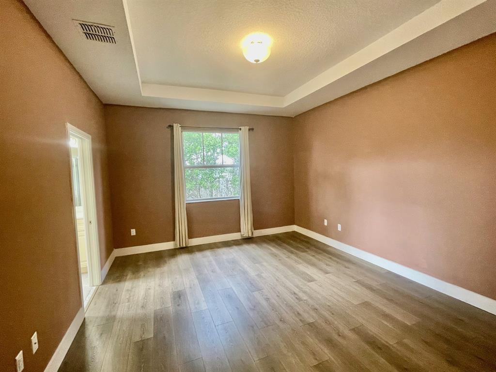 4803 Northwest 48th Terrace Tamarac, FL 33319 - Photo 12 of 28 an empty room with wooden floor and windows