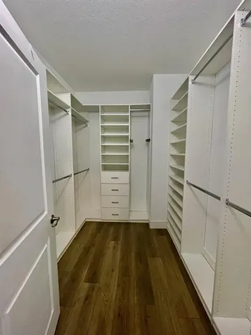 a view of walk in closet with empty racks