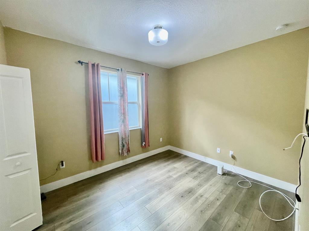 4803 Northwest 48th Terrace Tamarac, FL 33319 - Photo 19 of 28 a view of room with window and wooden floor
