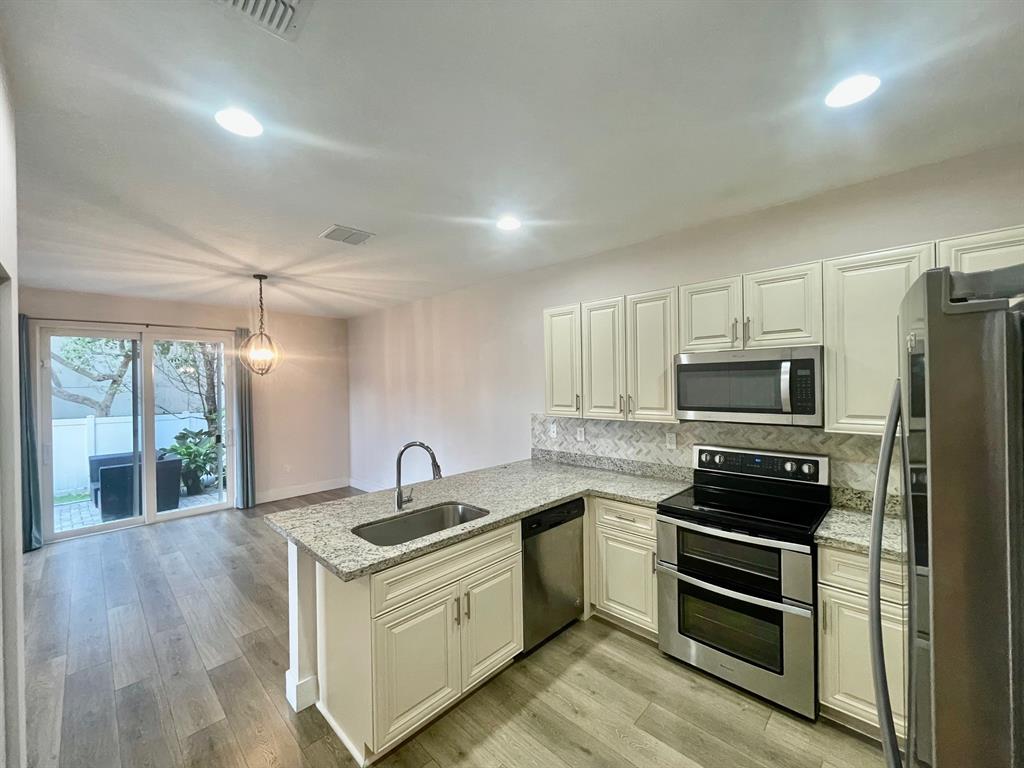 4803 Northwest 48th Terrace Tamarac, FL 33319 - Photo 2 of 28 a kitchen with a sink stove and refrigerator