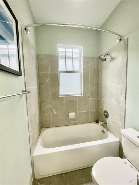 4803 Northwest 48th Terrace Tamarac, FL 33319 - Photo 22 of 28 a bathroom with a bathtub a window and a shower