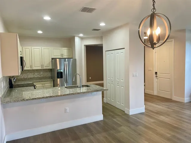 a view of a kitchen with a sink and refrigerator