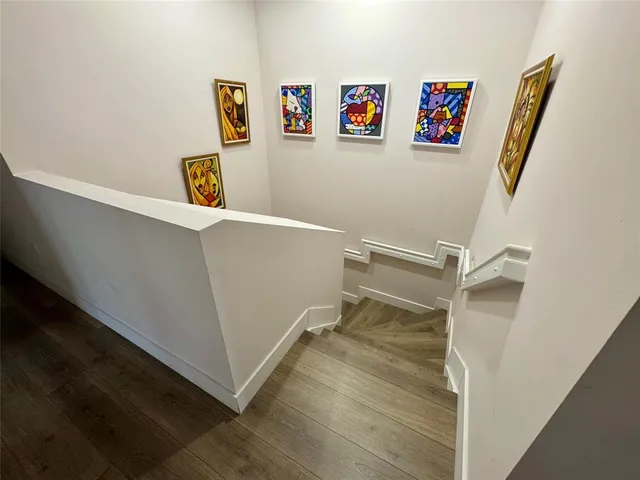 a view of room with refrigerator and wooden floor
