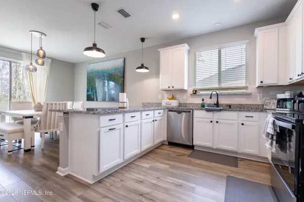 a kitchen with white cabinets sink and appliances