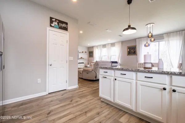 a kitchen with stainless steel appliances granite countertop a sink cabinets and wooden floor
