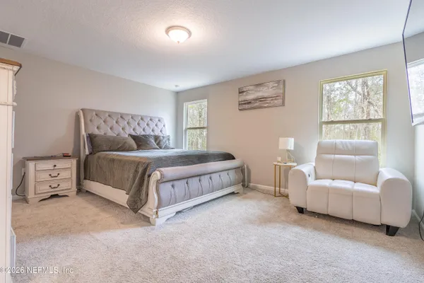 a spacious bedroom with a bed and a couch