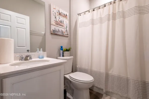 a bathroom with a sink a toilet and shower curtain