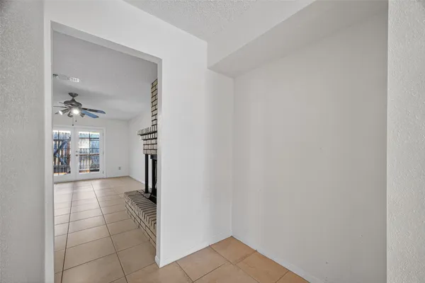 a view of a hallway view with wooden floor and a living room