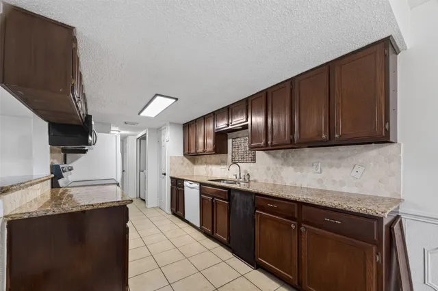 a kitchen with stainless steel appliances granite countertop a sink stove and cabinets