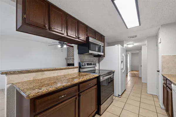 a kitchen with stainless steel appliances granite countertop a sink stove and cabinets