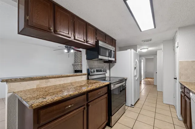 a kitchen with stainless steel appliances granite countertop a sink stove and cabinets