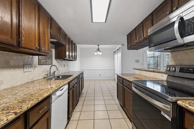 a kitchen with granite countertop stainless steel appliances and wooden cabinets