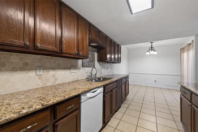 a kitchen with granite countertop stainless steel appliances a sink stove top oven and cabinets
