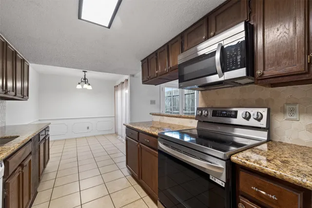 a kitchen with granite countertop stainless steel appliances and wooden cabinets