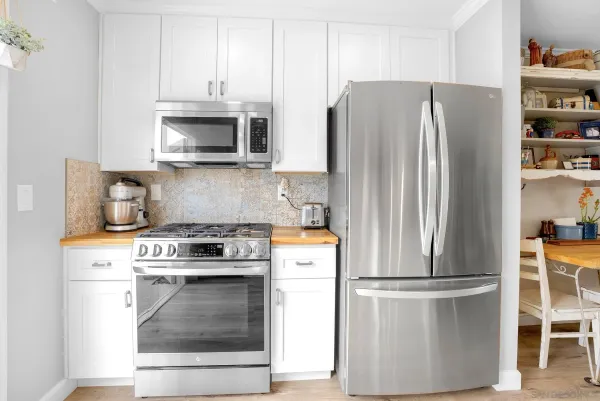 a large white kitchen with lots of counter space and a sink