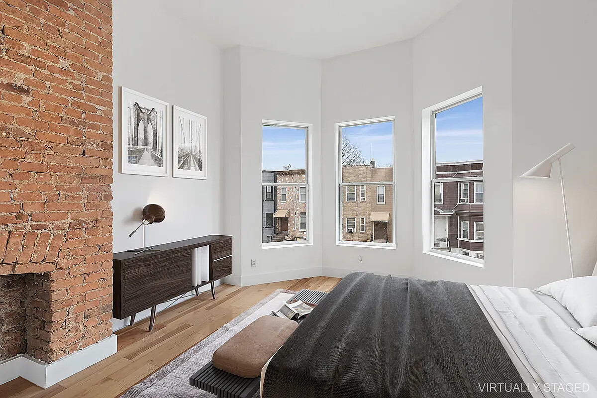 235 Covert Street Brooklyn, NY 11207 - Photo 14 of 15 a bedroom with a bed and a fireplace
