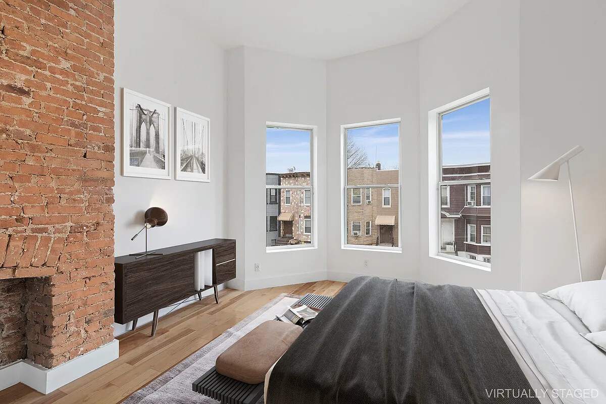 235 Covert Street Brooklyn, NY 11207 - Photo 4 of 15 a bedroom with a bed and a fireplace