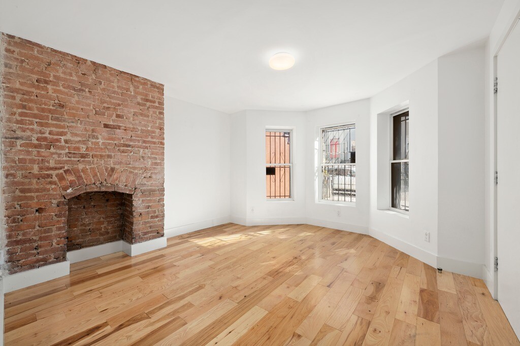 235 Covert Street Brooklyn, NY 11207 - Photo 7 of 15 a view of an empty room with window and fire place