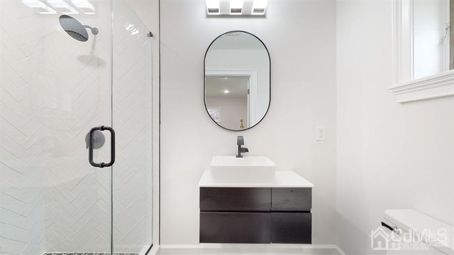 243 Old Tote Road Mountainside, NJ 07092 - Photo 20 of 42 a bathroom with a sink a mirror and shower