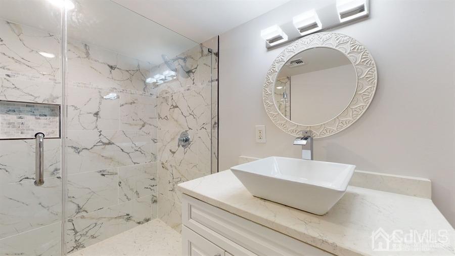 243 Old Tote Road Mountainside, NJ 07092 - Photo 36 of 42 a bathroom with a sink a mirror and shower