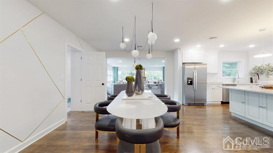 243 Old Tote Road Mountainside, NJ 07092 - Photo 6 of 42 a kitchen with stainless steel appliances kitchen island granite countertop a refrigerator a stove a sink a dining table and chairs with wooden floor