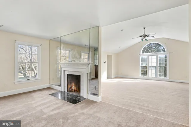 a view of an empty room with window and fire place