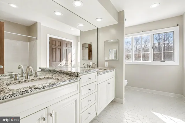 a bathroom with a granite countertop sink mirror and double