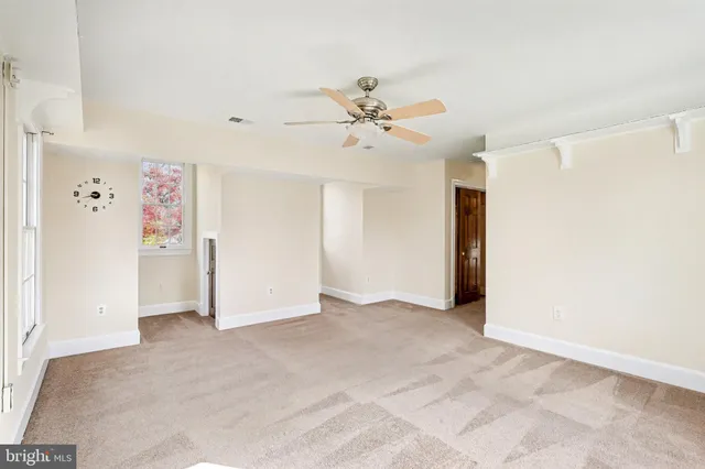 an empty room with closet and a ceiling fan
