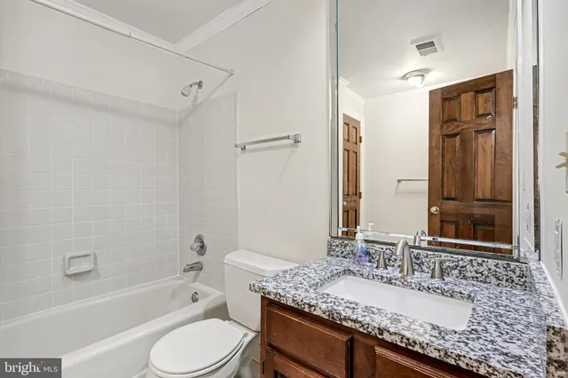 a bathroom with a granite countertop sink toilet mirror and shower