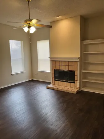 a view of a livingroom with wooden floor a fireplace and window