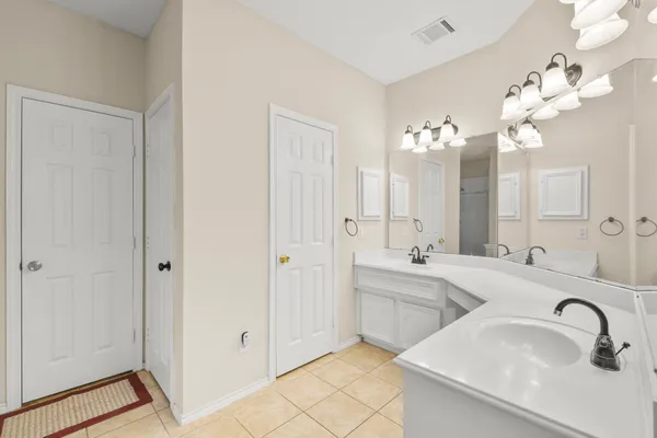 a bathroom with a sink double vanity granite tub shower and a mirror