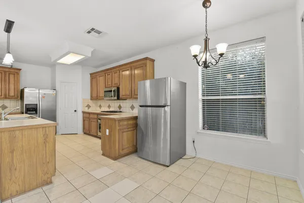 a kitchen with stainless steel appliances granite countertop a refrigerator a sink dishwasher a oven with white cabinets