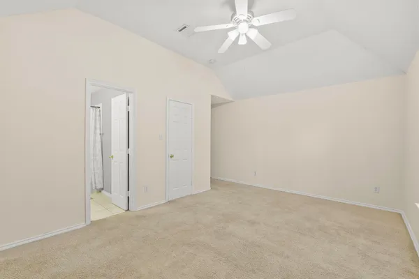 an empty room with a ceiling fan and a fan