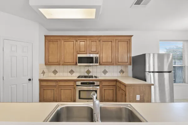 a kitchen with a sink a refrigerator and a stove top oven