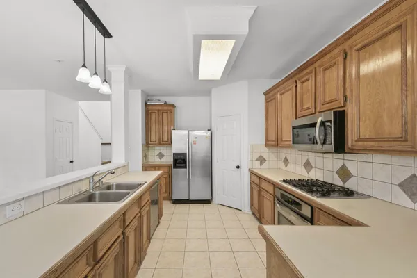 a kitchen with stainless steel appliances granite countertop a sink stove and refrigerator