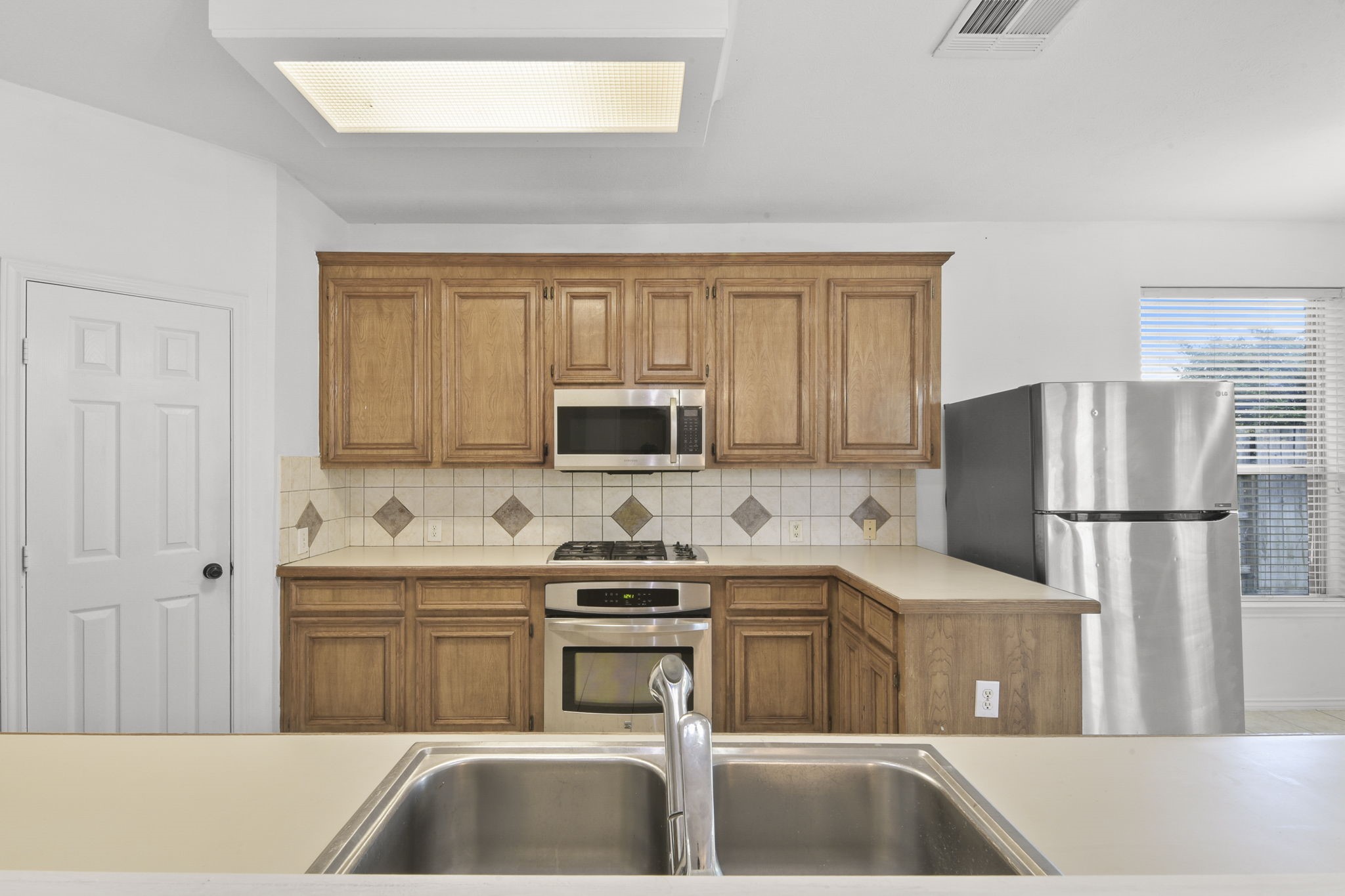 8550 Waiting Spring Circle Houston, TX 77095 - Photo 8 of 32 a kitchen with a sink a refrigerator and a stove top oven