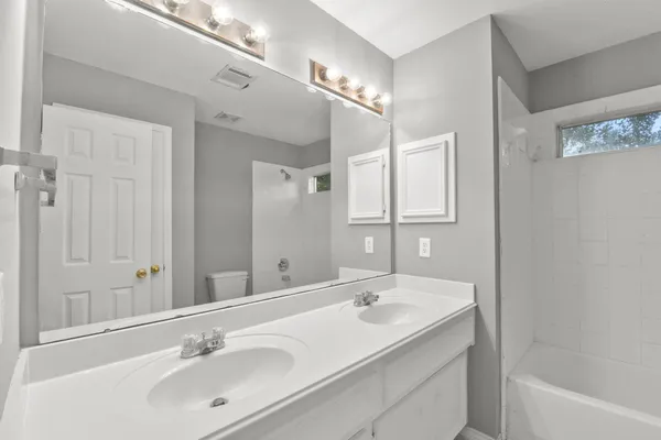 a bathroom with a sink double vanity granite tub and a mirror