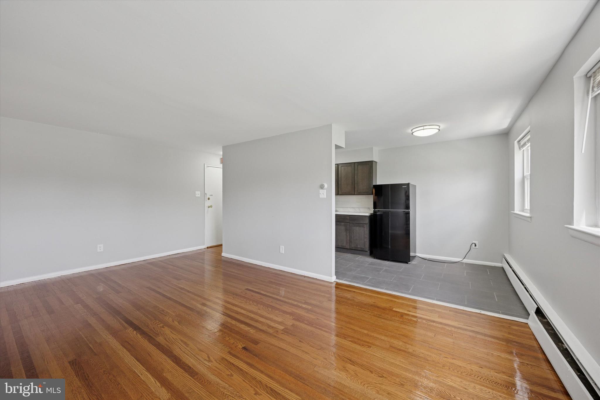 8410 Bustleton Avenue, Unit A 14 Philadelphia, PA 19152 - Photo 11 of 15 a view of an empty room with wooden floor and kitchen