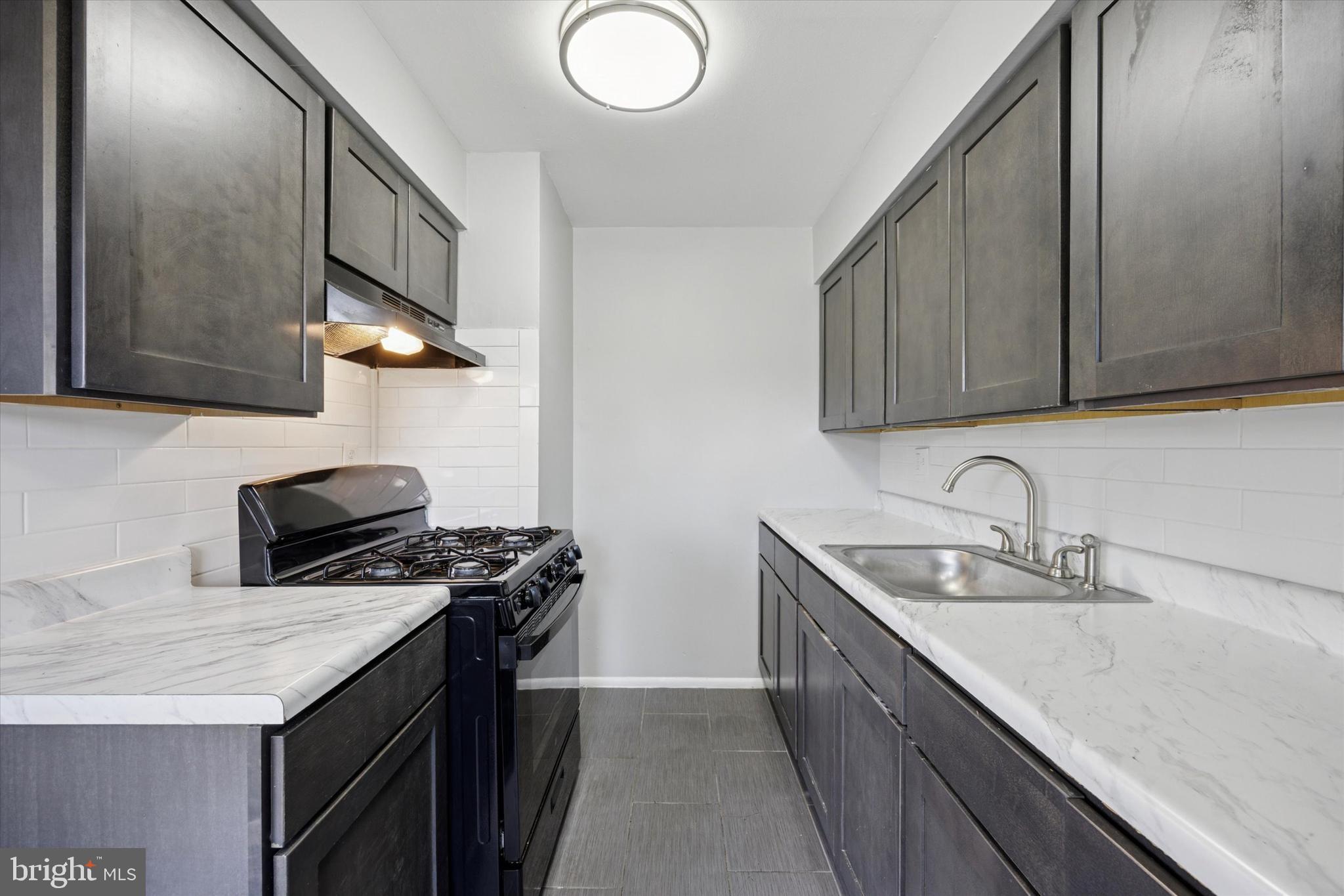 8410 Bustleton Avenue, Unit A 14 Philadelphia, PA 19152 - Photo 13 of 15 a kitchen with stainless steel appliances granite countertop a sink stove and refrigerator