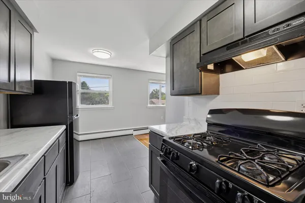 a stove top oven sitting inside of a kitchen