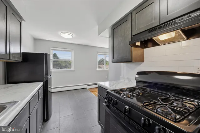 a stove top oven sitting inside of a kitchen