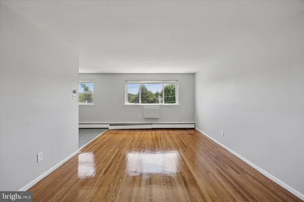 a view of a room with wooden floor and white walls